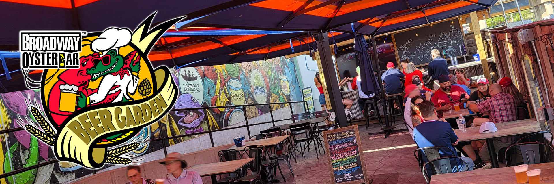 Broadway Oyster Bar Beer Garden photo with people enjoying drinks at tables with umbrellas